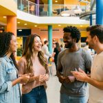 12 activités indoor dans le Finistère pour les jours de pluie Groupe de quatre jeunes adultes souriants échangeant dans un espace de loisirs couvert, moderne, coloré et chaleureux.